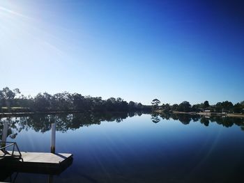 Scenic view of lake against clear blue sky