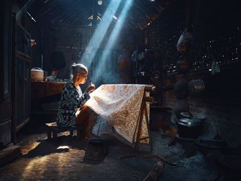 WOMAN STANDING IN ILLUMINATED ROOM