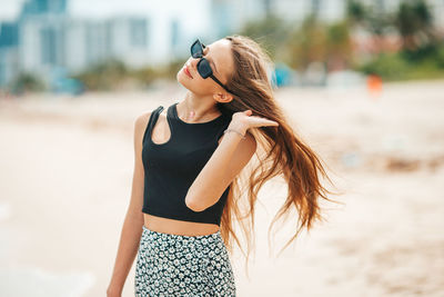 Rear view of young woman standing at beach
