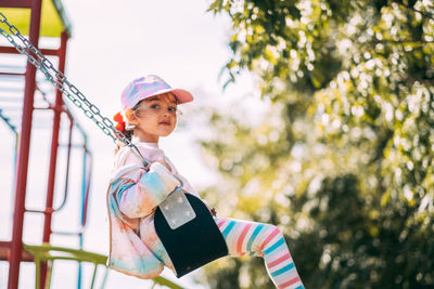 Portrait of adorable little girl swinging