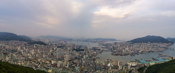 High angle view of city by sea against sky