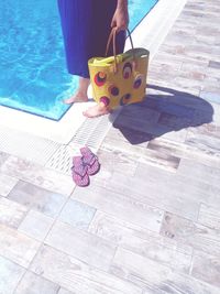 Women in holiday near the swimming pool with yellow bag