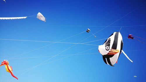 Low angle view of kite flying against clear blue sky