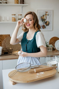 Portrait of smiling young woman drinking coffee at home