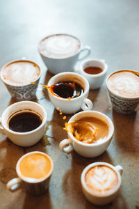 Vertical view of the many cups of coffee standing on stone table