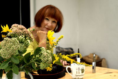 Portrait of young woman with yellow flowers