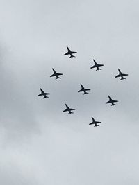 Low angle view of airplanes flying against sky