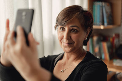 Portrait of mid adult woman using mobile phone