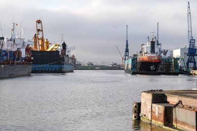 Commercial dock by harbor against sky