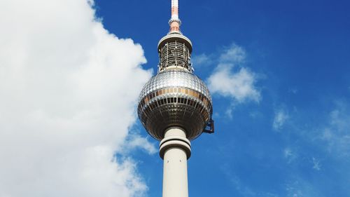 Low angle view of communications tower against blue sky during sunny day