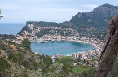 High angle view of city by sea against sky