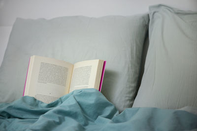 Midsection of person relaxing on bed at home