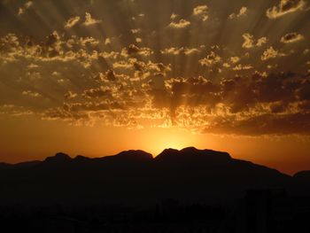 Scenic view of silhouette mountains against romantic sky at sunset