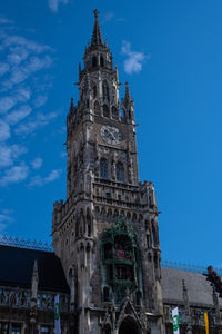 Low angle view of clock tower against blue sky