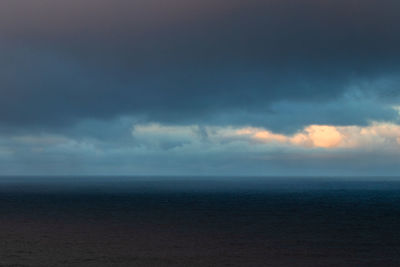 Scenic view of sea against storm clouds