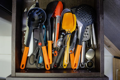 Mess in the cutlery drawer. top view of various kitchen utensils without organization.