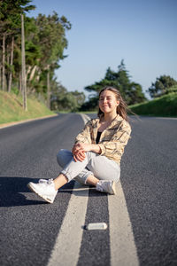 Young woman sitting on road