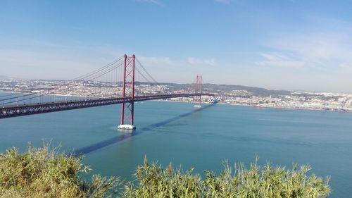 Scenic view of 25 de abril bridge over tagus river against sky