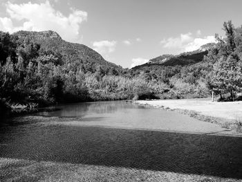 Scenic view of lake by mountains against sky