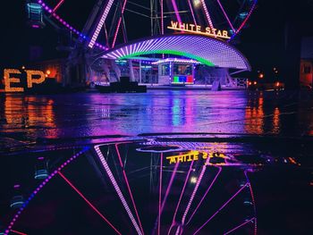 Illuminated ferris wheel in city at night