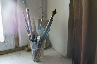 Painting brushes in the glass on the old windowsill. selective focus on brushes. blurred background