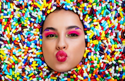 Close-up portrait of woman in multi colored capsules