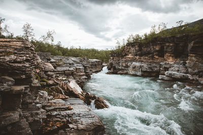 Scenic view of waterfall against sky