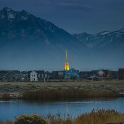 Buildings by river in town at dusk