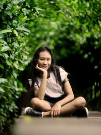 Portrait of a smiling young woman sitting outdoors