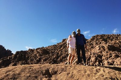 Men standing on landscape against sky