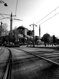 Railroad tracks in city against clear sky