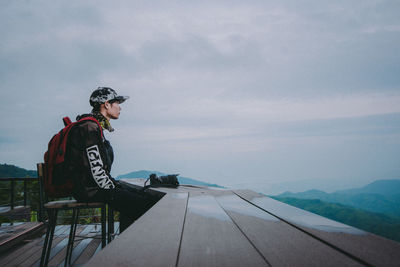 Full length of man looking at mountain against sky