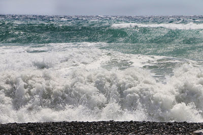 Close-up of wave on beach against sky