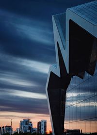 Low angle view of modern buildings against sky at sunset