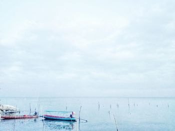 Boats moored on sea against sky