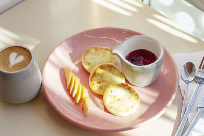 Breakfast in the cafe cheesecakes with fruit and coffee, hard light