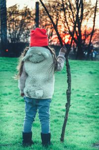 Rear view of child standing on snow covered landscape