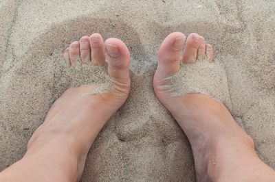 Low section of person on sand at beach