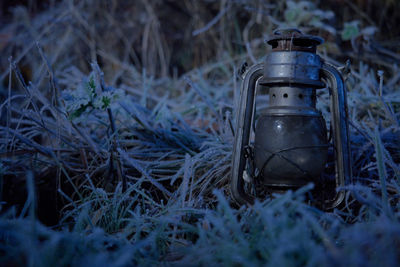 Close-up of abandoned lantern on field