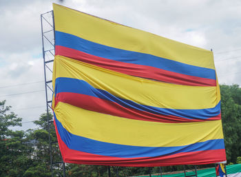 Multi colored flag flags against blue sky