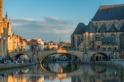 Bridge over river against buildings in city