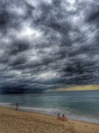 Scenic view of beach against cloudy sky