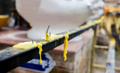 Close-up of yellow wax on metal