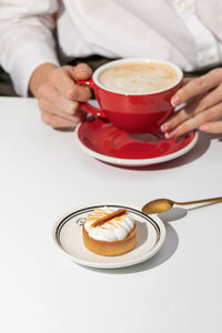 Midsection of man holding coffee on table