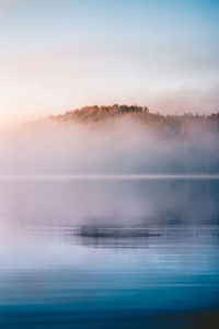 Scenic view of sea against sky during sunset in the fog