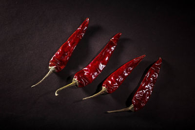 Close-up of red chili pepper on table against black background