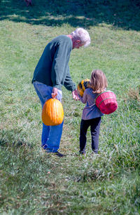 Young girl and grandpa finding perfect halloween pumpkins