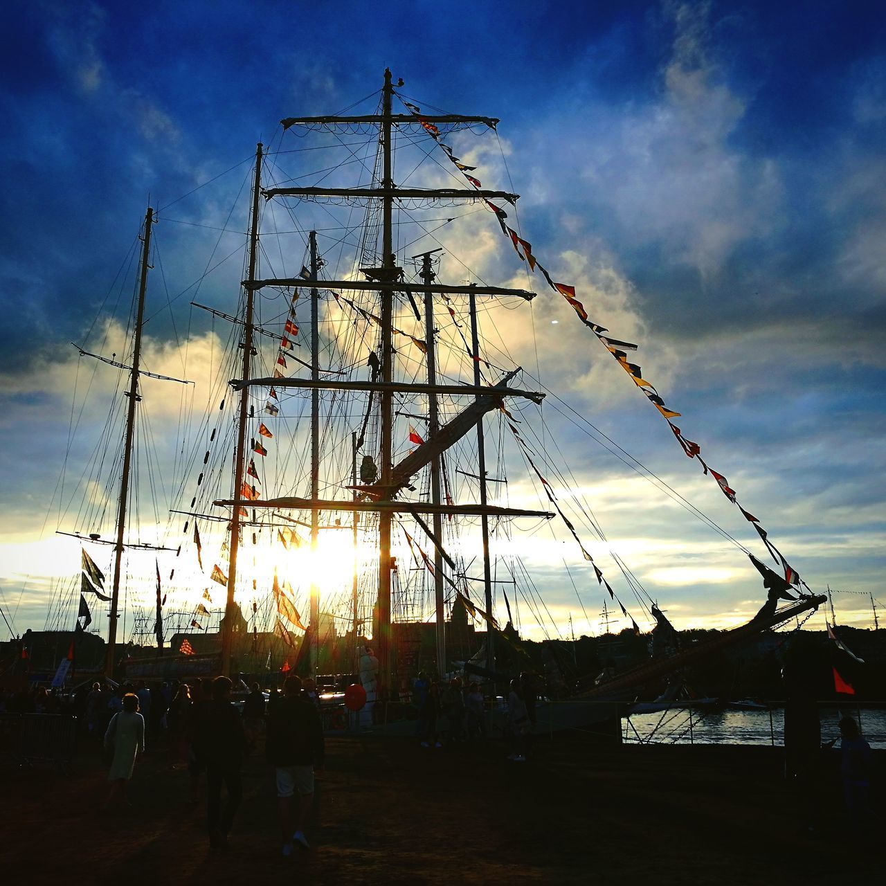 LOW ANGLE VIEW OF SAILBOATS IN SEA AT SUNSET