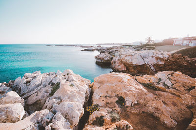 Rocks on beach against clear sky