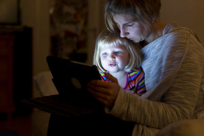 Mother and daughter looking at digital tablet at home